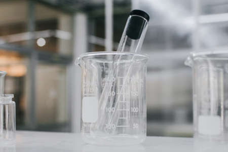 Beaker and test tubes in chemistry science laboratory background. Laboratory glassware for research and development concept.の写真素材