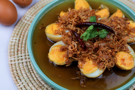 Fried egg with tamarind sauce or Sweet and Sour Eggs topped with fried onions and dried chilies....