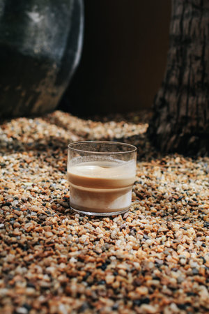 Dirty coffee latte on abstract colorful mini granite crushed stones ground texture background. Light...