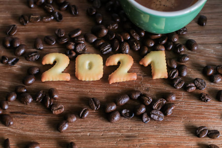 2021 bread number and  coffee cup on wooden table with coffee beans.Happy new year 2021, Holidays...