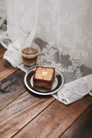 French bread toasted butter on the plate with coffee for breakfast with vintage knife or brunch.
