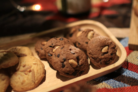 Tasty homemade Christmas cookies and croissant with light on wooden plate. Festive food, family culinary, Christmas and New Year traditions conceptの写真素材