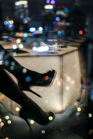 Abstract shadow of sexy woman in high heel with city urban futuristic architecture background. Motion blur, reflection in glass of high rise skyscraper facade. City night life concept.の写真素材