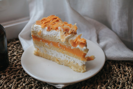 Delicious cake almond whipped cream filling, topped with caramel and almond.  Piece of Cake on a Plate. Sweet food. Sweet dessert.の写真素材