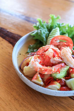 Spicy Thai fruit salad with Shrimps on wooden table at cafe , Thai spicy style healthy food Thai cuisine.の写真素材