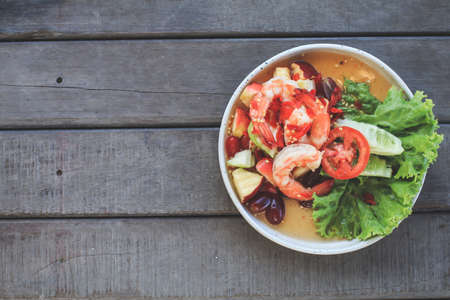 Spicy Thai fruit salad with Shrimps on wooden table at cafe , Thai spicy style healthy food Thai cuisine.の写真素材