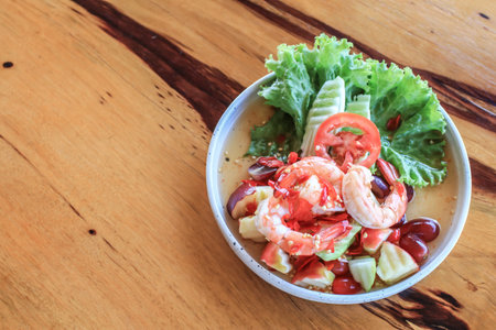 Spicy Thai fruit salad with Shrimps on wooden table at cafe , Thai spicy style healthy food Thai cuisine.の写真素材