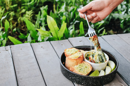 Baked spinach with cheese and garlic bread on wooden table - Italian food style.の写真素材