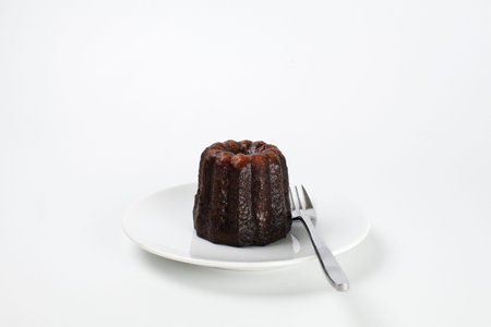 Caneles de bordeaux - traditional French sweet dessert serve with tea or coffee. on white background.の写真素材