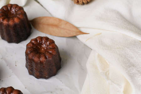 Caneles de bordeaux - traditional French sweet dessert serve with tea or coffee on wooden background.の写真素材