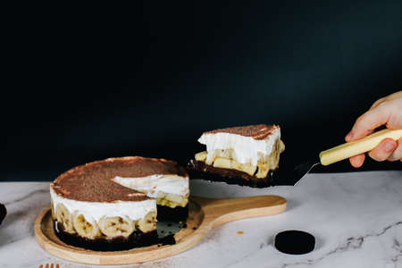 Banoffee cake with bananas, whipped cream, chocolate, caramel, coffee and toffee in cafe restaurantの写真素材