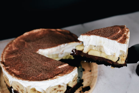 Banoffee cake with bananas, whipped cream, chocolate, caramel, coffee and toffee in cafe restaurant