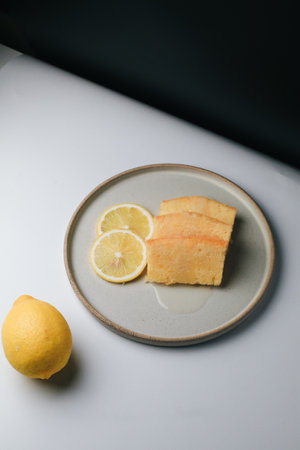 Lemon pound cake with slices of lemon sugar icing on black and white background. Delicious breakfast, traditional tea time treat. Recipe of English lemon pie loaf.の写真素材