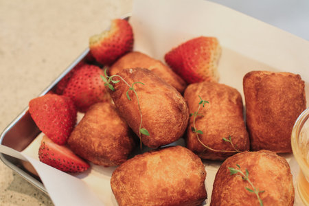 Traditional French beignets doughnuts with strawberry and powdered sugar. Usually yeasted and raised...