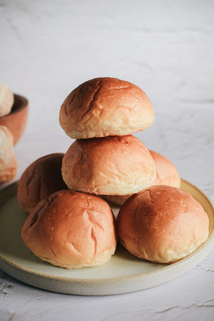 Freshly baked bread. Organic whole-wheat loaves on white background. Mini bread pile. Bakery bread...