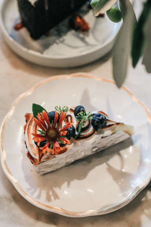 Lemon pie with meringue on the table with citrus fruits. Traditional french sweet pastry tart. Delicious, appetizing, homemade dessert with lemon curd cream.の写真素材