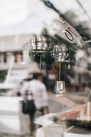 Close-up of espresso pouring from coffee machine. Professional coffee brewing. Barista Cafe Coffee...