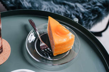 Orange cake with orange topping on a plate. Top view, blank space, vintage toned image. Sweet food and drinkの写真素材