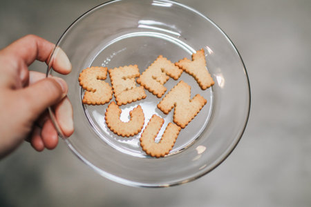 Plate with alphabet Biscuits on wooden table with bluer background. Top view photo.