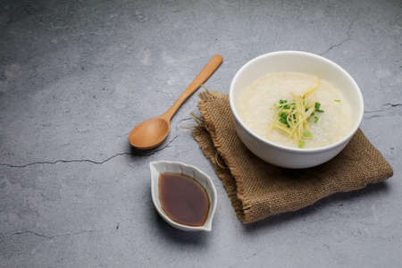 Rice porridge or Congee with fresh ginger and coriander, is a favorite breakfast for south east asian people.の写真素材