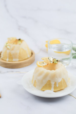 Lemon cake with sugar frosting on marble table. Healthy dessert. Delicious breakfast, traditional tea time treat. Modern summer food minimal concept, copy spaceの写真素材