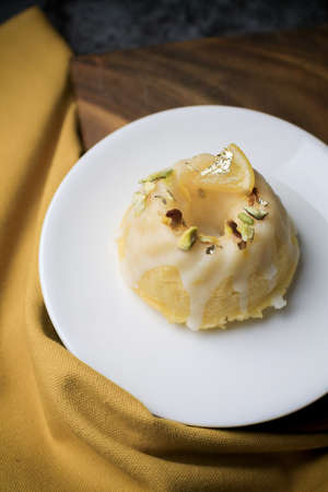 Lemon pound cake served for dessert on white plate in dark background. This cake made from lemon juice, butter, and other ingredients. The taste of the cake is sweet and sour.の写真素材