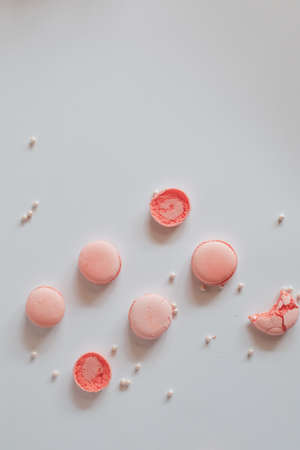 Pink macaron cookies and rose flowers on white background. French cookie. Soft pastel vintage tone.の写真素材