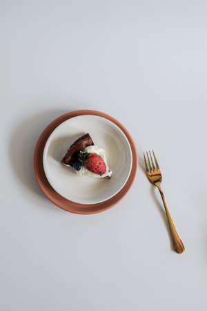 Delicious chocolate flourless cake with strawberry, blueberry and whipping cream on white background. Homemade bakery conceptの写真素材