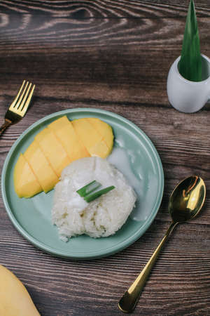 Delicious mango sticky rice serve with coconut milk on wooden table. Popular traditional dessert of Thailand.の写真素材
