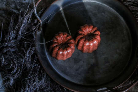 Caneles de bordeaux on dark background with sunrise. French pastry Canele rum and vanilla flavor thick caramelized crustの写真素材