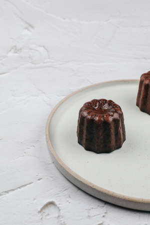 Caneles de bordeaux - traditional French sweet dessert. Rum and Vanilla Flavors with a Tender Custard Center and a Thick Caramelized Crust.の写真素材