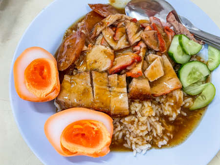 Crispy belly pork on rice with barbecue red sauce and Egg topped. It is a delicious menu of Thai. Close up photo.の写真素材