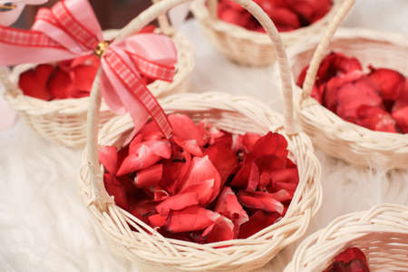 Basket of red rose petals in wedding ceremony. Close-up, copy space, toned. wedding decoration.の写真素材