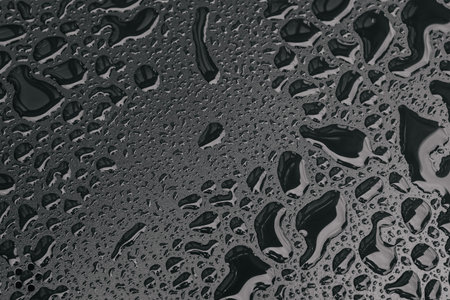 Water drops on black surface background. Raindrops for overlaying on window, concept of autumn...