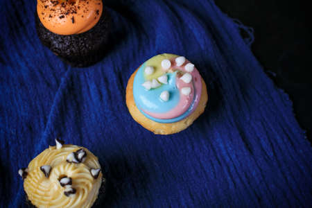 Delicious Cupcakes with whipped chocolate and vanilla cream for party, birthday on dark background.の写真素材