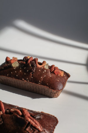 Homemade banana bread with walnut under morning sunlight from window on white background....