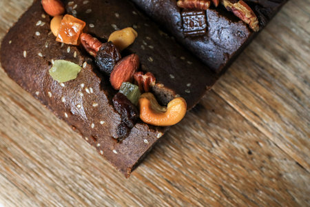 Homemade vegan banana bread with nut sliced on a cutting Board on a Wooden Kitchen Table. Healthy...