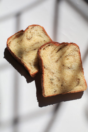 Sliced black truffle and cheese Brioche bread on white background under morning from window.の写真素材