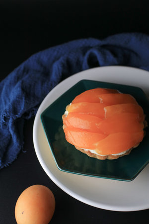 Cheese cake decorated with Mayongchid or plum mango on dark background. Homemade bakery concept with...