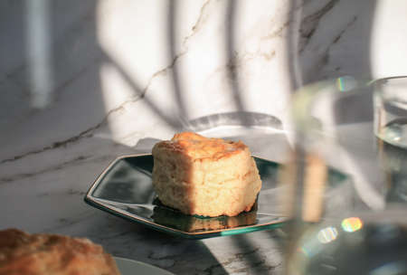 Homemade sweet scones on plate under morning sunlight. Fresh yummy tasty delicious English pastry for afternoonの写真素材