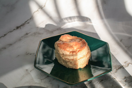 Homemade sweet scones on plate under morning sunlight. Fresh yummy tasty delicious English pastry for afternoonの写真素材