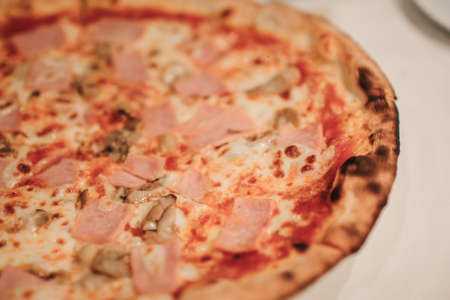 Pizza with bacon ham and sausage on dinner table. People with favour italian dish conceptの写真素材