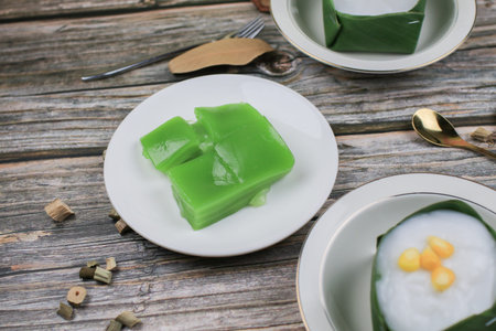 Steamed Layer sweet cake or Khanom Chan Thai traditional dessert (Green Pandan flavour) in white plate. Famous desserts in Thailand.の写真素材