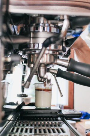 Espresso pouring from coffee machine. Professional coffee brewing. Delicious morning.の写真素材