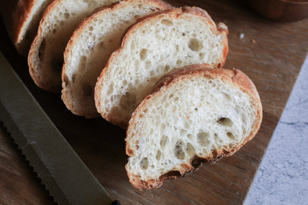 French Baguette bread on wooden cutting board background. Bread bun, Tasty delicious crusty bread in...