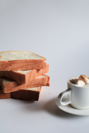 Homemade slide bread and hot coffee with marshmallow on white background. Morning breakfast concept....