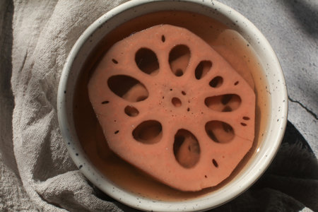 Cold boiled Lotus root with syrup in white bowl. Thailand dessert. Lotus root has unique characteristic that it has many holes in it which is good for healthの写真素材