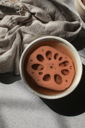 Cold boiled Lotus root with syrup in white bowl. Thailand dessert. Lotus root has unique characteristic that it has many holes in it which is good for healthの写真素材