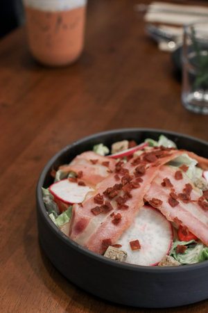 Salad with bacon, croutons and lettuce close-up on a plate on a table. Classic American salad, food. Healthy Keto diet. Copy space.の写真素材
