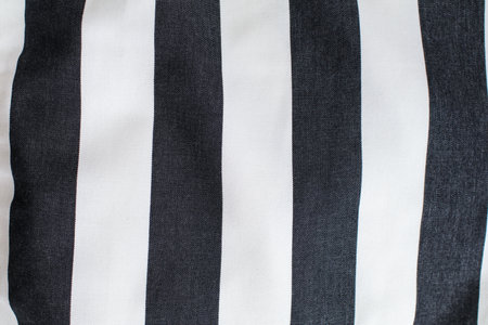 Striped wrinkled black and white piece of a cloth fabric as a background texture. Modern stylish wallpaper.の写真素材